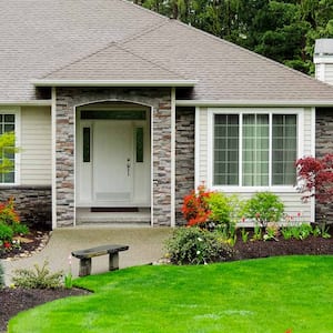 House with mulched flowerbeds and mature plants