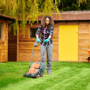  A woman mowing the lawn in the backyard