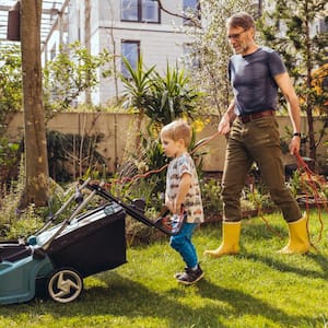 Father and son mowing the lawn together