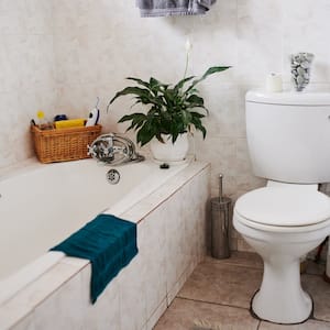 home bathroom with toilet, tile floors and objects placed around bathtub shower combo