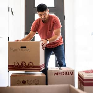 A man lifting a moving cardboard box