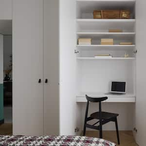 A desk situated inside a wardrobe in a room