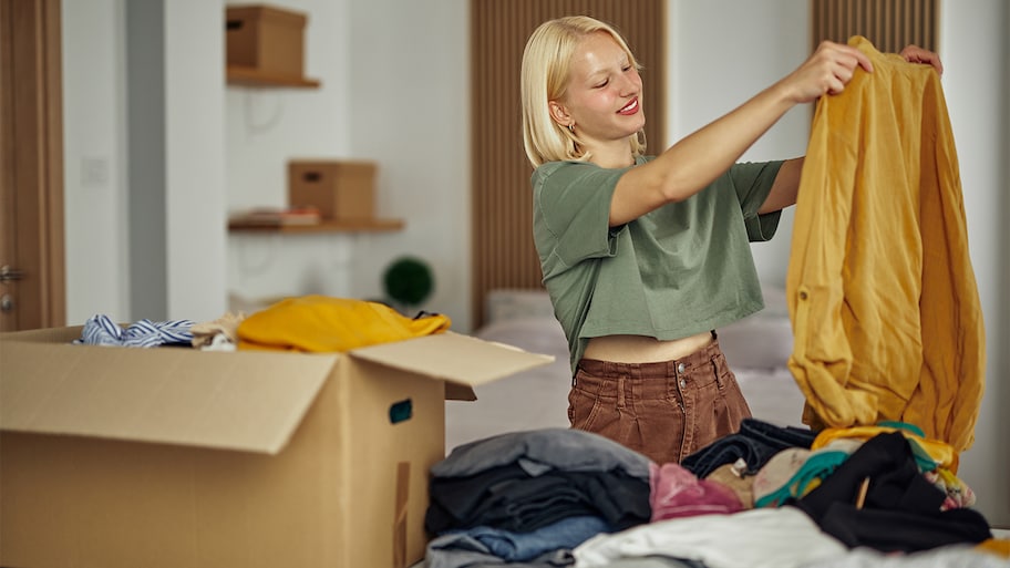 woman folding clothes to donate 