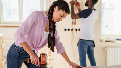 woman sanding a piece of wood