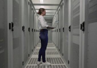 Female IT Pro using a Latitude 9430 notebook while inspecting data center operations.