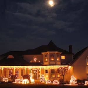 House lit up with Christmas lights under the moon