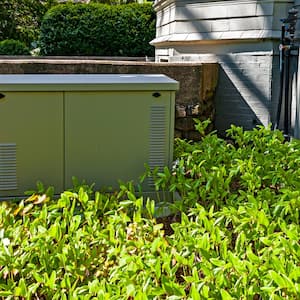 A residential standby generator installed on a concrete pad