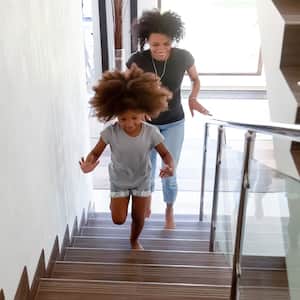 Mother and daughter running upstairs