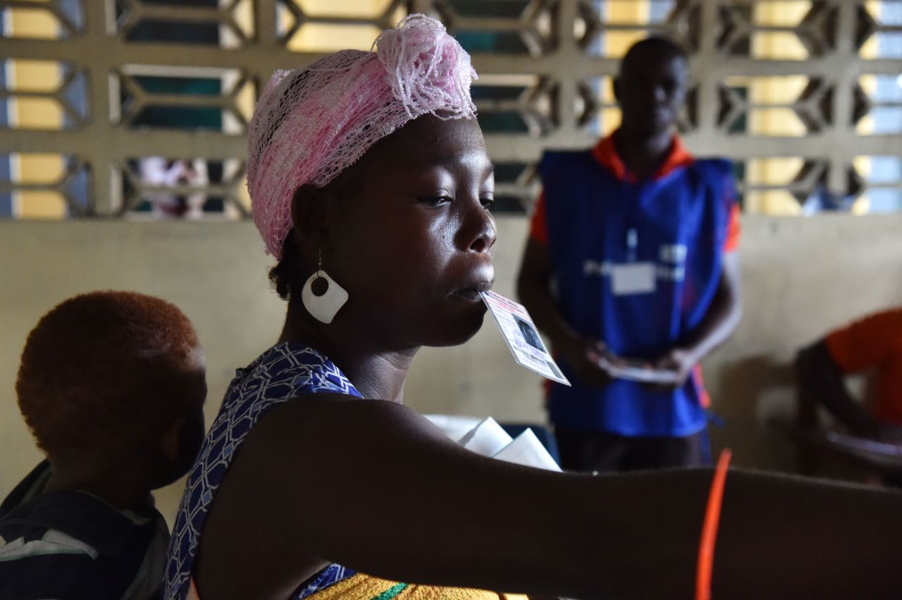 A woman carrying a child on her back casts her ballot. <br /><br />Credit: Getty images