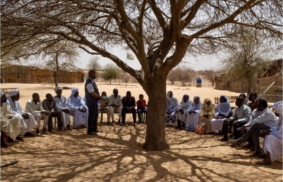 People sitting in a reunion under a tree