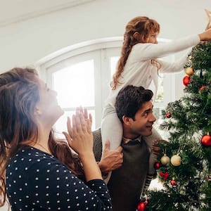 A family decorates a christmas tree
