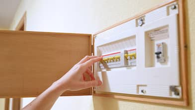 A woman turning off a fuse box in her house