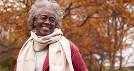 Purchased - an older woman smiling in the park during the fall