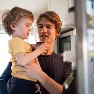 A father with his toddler in front of the fridge