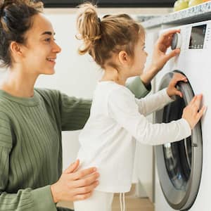  Daughter helping mom loading the dryer