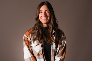 A brunette female smiles for a photo