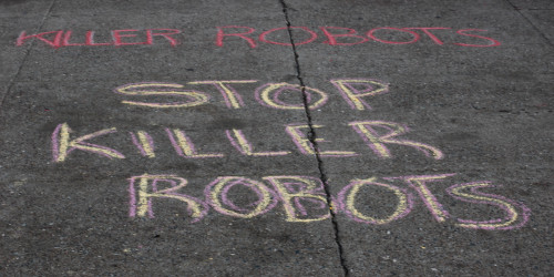 chalk on the sidewalk reading "STOP KILLER ROBOTS" 