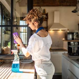 A woman cleaning a house’s windows