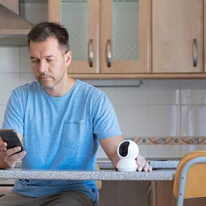 Man setting up security camera with a smartphone