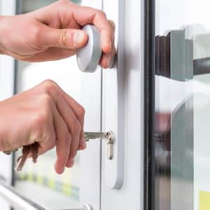 A woman opening the front door with a key