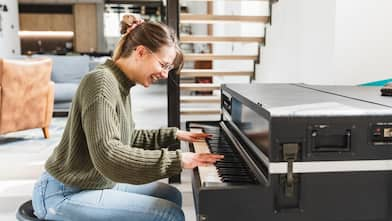 A woman playing piano in living room