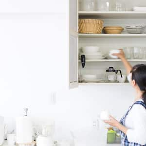 A woman cleaning her kitchen cabinets