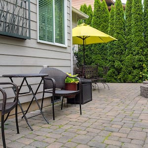 Backyard patio with chairs and table on brick pavers