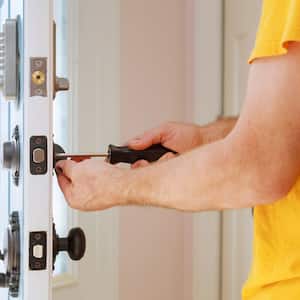 A locksmith changes a door’s lock