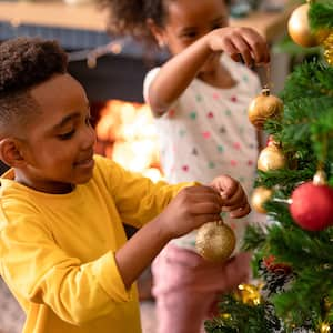 Siblings decorating a Christmas tree