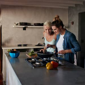 Two young women cooking on a kitchen island