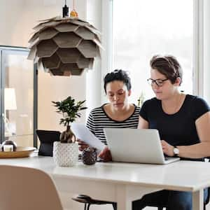 couple discussing financial bills over laptop while sitting at table