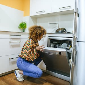 woman in the kitchen looking at dishwasher
