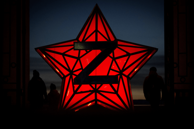 Pedestrians stand next to a New Year's decoration stylized as the "Kremlin Star," bearing a letter "Z," a tactical insignia of Russian troops in Ukraine, in Moscow.