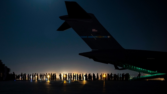 Evacuees line up to board a C-17 aircraft in support of the Afghanistan evacuation at Hamid Karzai International Airport on Aug. 21, 2021, in Kabul, Afghanistan.