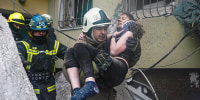 A firefighter carries a wounded woman out of the rubble after a Russian rocket attack on Saturday in Dnipro, Ukraine.