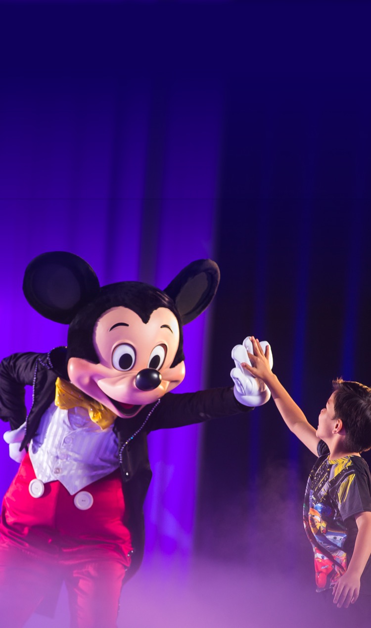 Mickey Mouse high fives young boy during live show