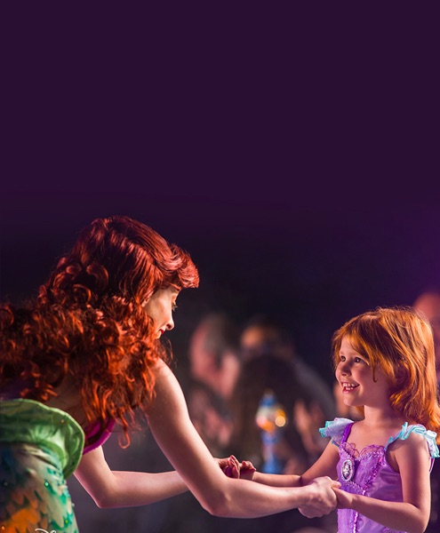 Arial holding a young girls hands during a show