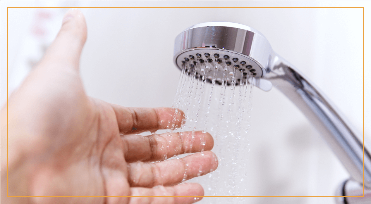 hand under shower faucet checking water pressure