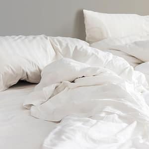 A white messy bed with pillows