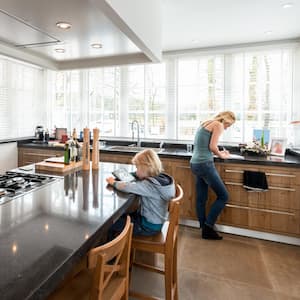 A mother and a daughter in modern kitchen with granite countertop