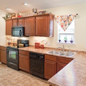 kitchen with wood cabinets, vinyl countertop, and black appliances