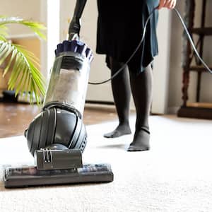 woman vacuuming a carpet