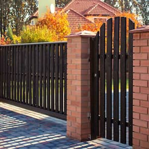 A sliding and a pedestrian gate between brick columns