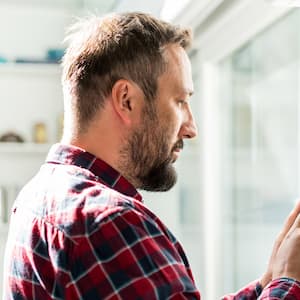 Man using smart home thermostat device