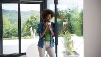 Woman drinking coffee and looking out the window