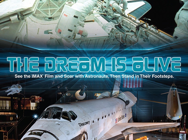 picture of a space station and the discovery space shuttle with the words "the dream is alive" going across