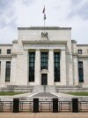 FILE - An American flag flies over the Federal Reserve Board Building in Washington, May 4, 2021.