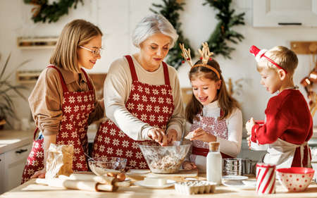 Happy family with children cooking together on christmas day in cozy home kitchen