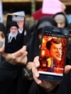 A protester shows a cartoon of French President Emmanuel Macron during a protest condemning the French magazine Charlie Hebdo for republishing cartoons insulting Iran's Supreme Leader Ayatollah Ali Khamenei, in Tehran, Iran, Jan. 11, 2023.