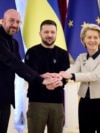 Ukrainian President Volodymyr Zelenskyy, center, European Commission President Ursula von der Leyen, right, and European Council President Charles Michel shake hands during the EU-Ukraine summit in Kyiv, Ukraine, Feb. 3, 2023. (Ukrainian Presidential Press Office via AP) 